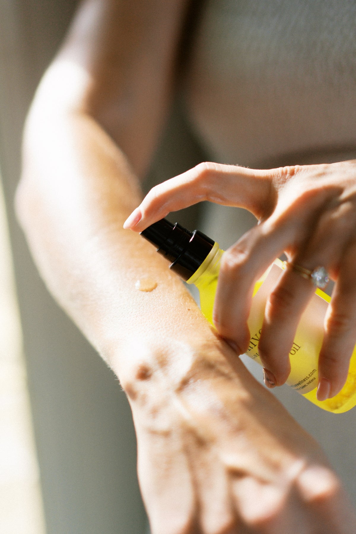 Person applying body oil to their arm