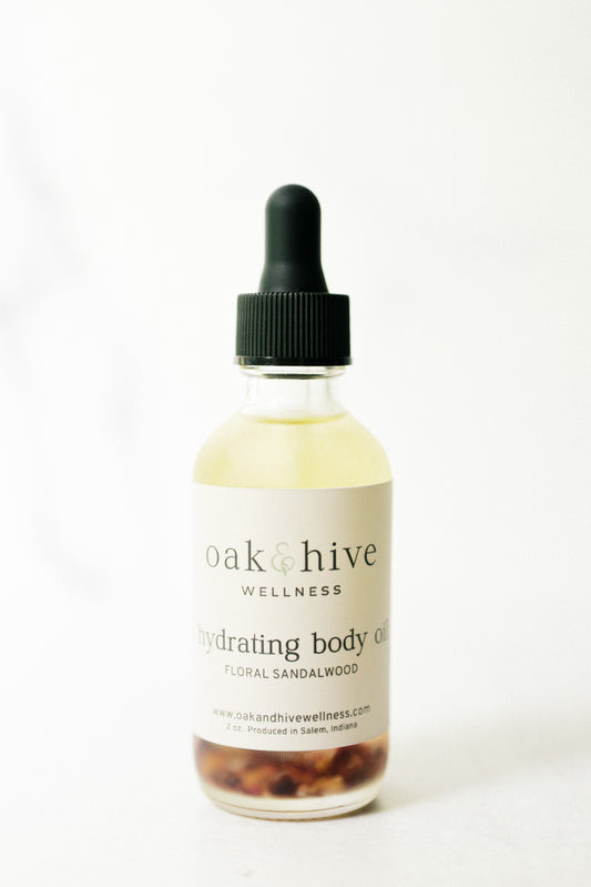 Bottle of 'oak & hive' floral sandalwood body oil on a white background