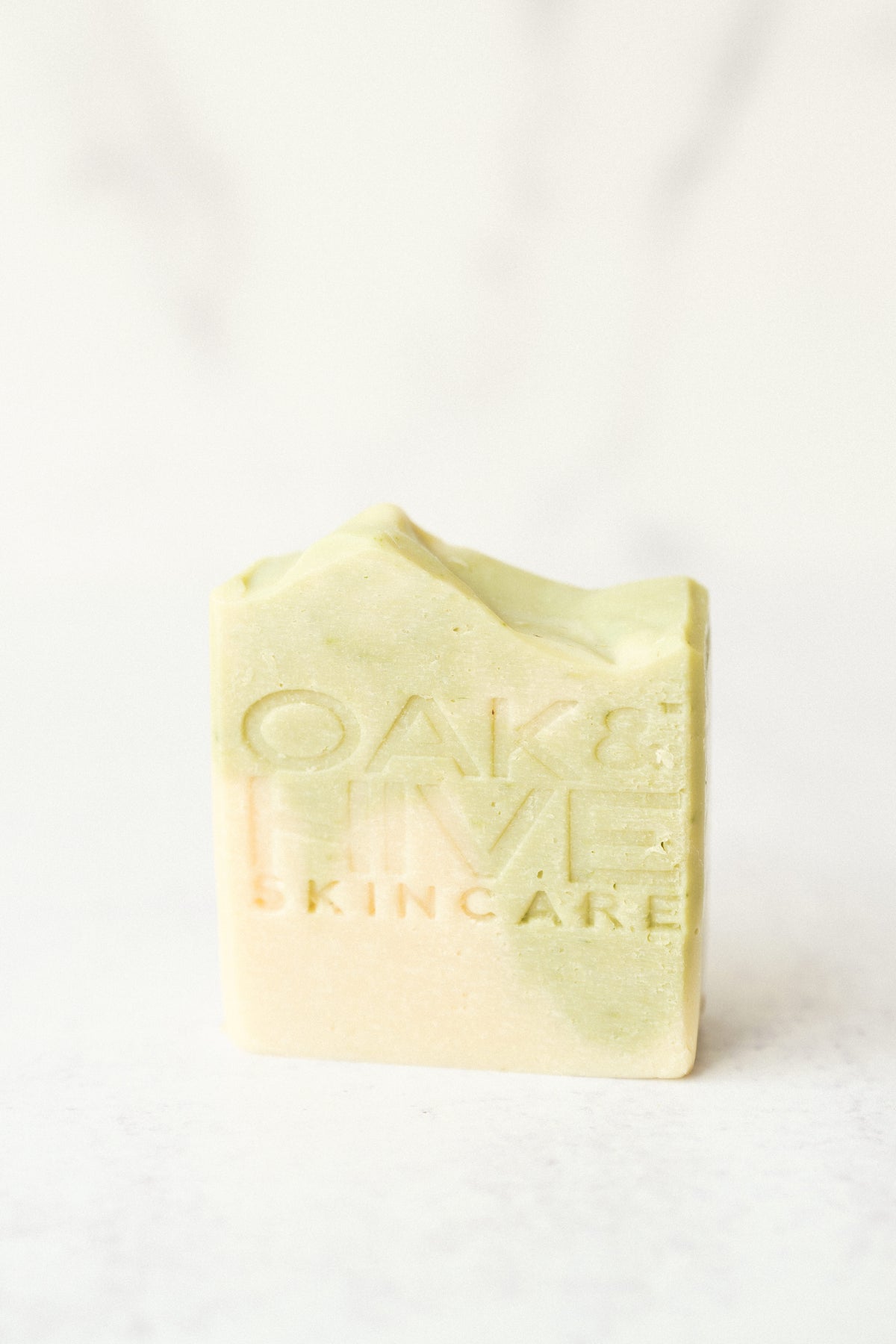 a green and white swirled bar of soap with a white background