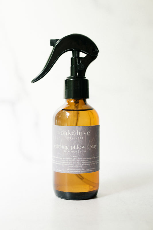 A bottle of Oak & Hive Calming Pillow spray. A amber bottle with a purple label and a white background. 