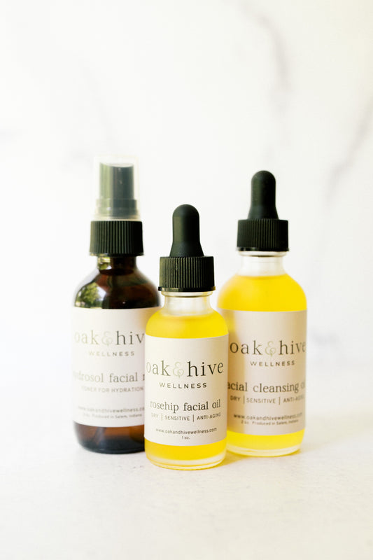 Three bottles of Oak + Hive Wellness products on a white background for dry and sensitive skin. 