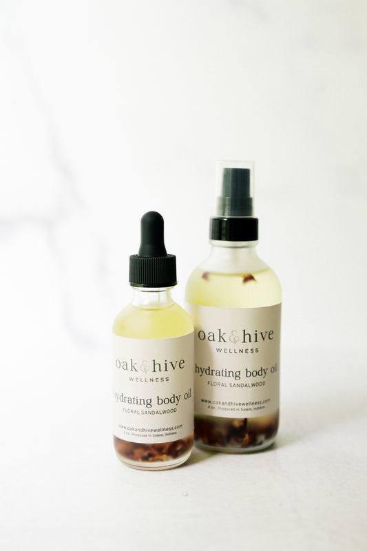Two bottles of 'oak & hive' floral sandalwood body oils on a white background
