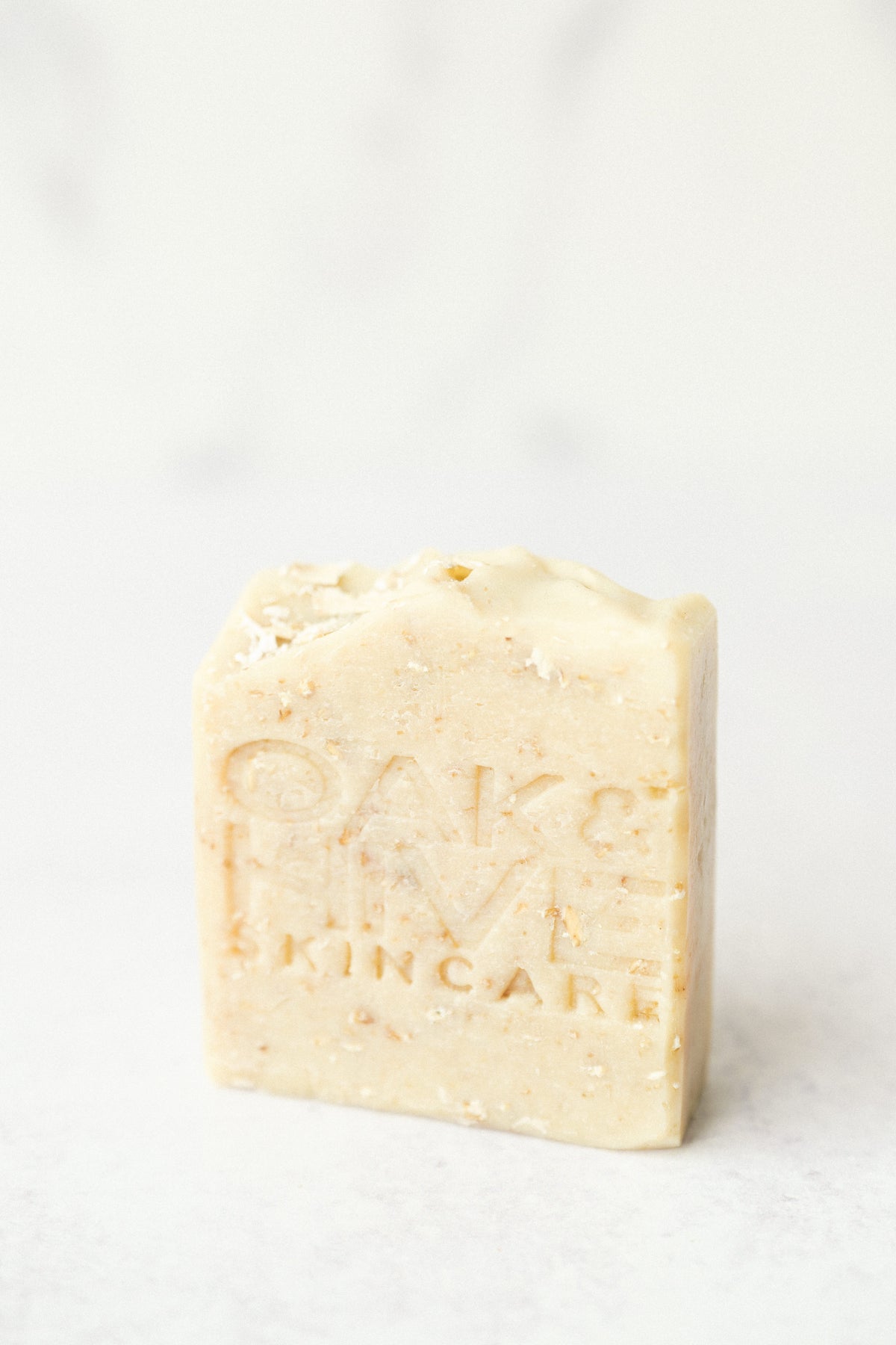 a tan soap with white and brown flakes on a white background