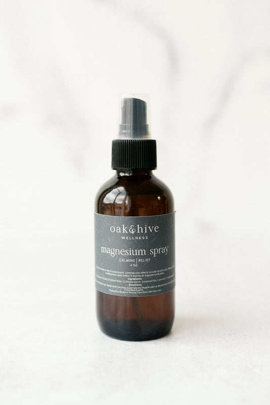 A bottle of Oak & Hive Magnesium Spray with lavender and chamomile, with a green label and a white background. 