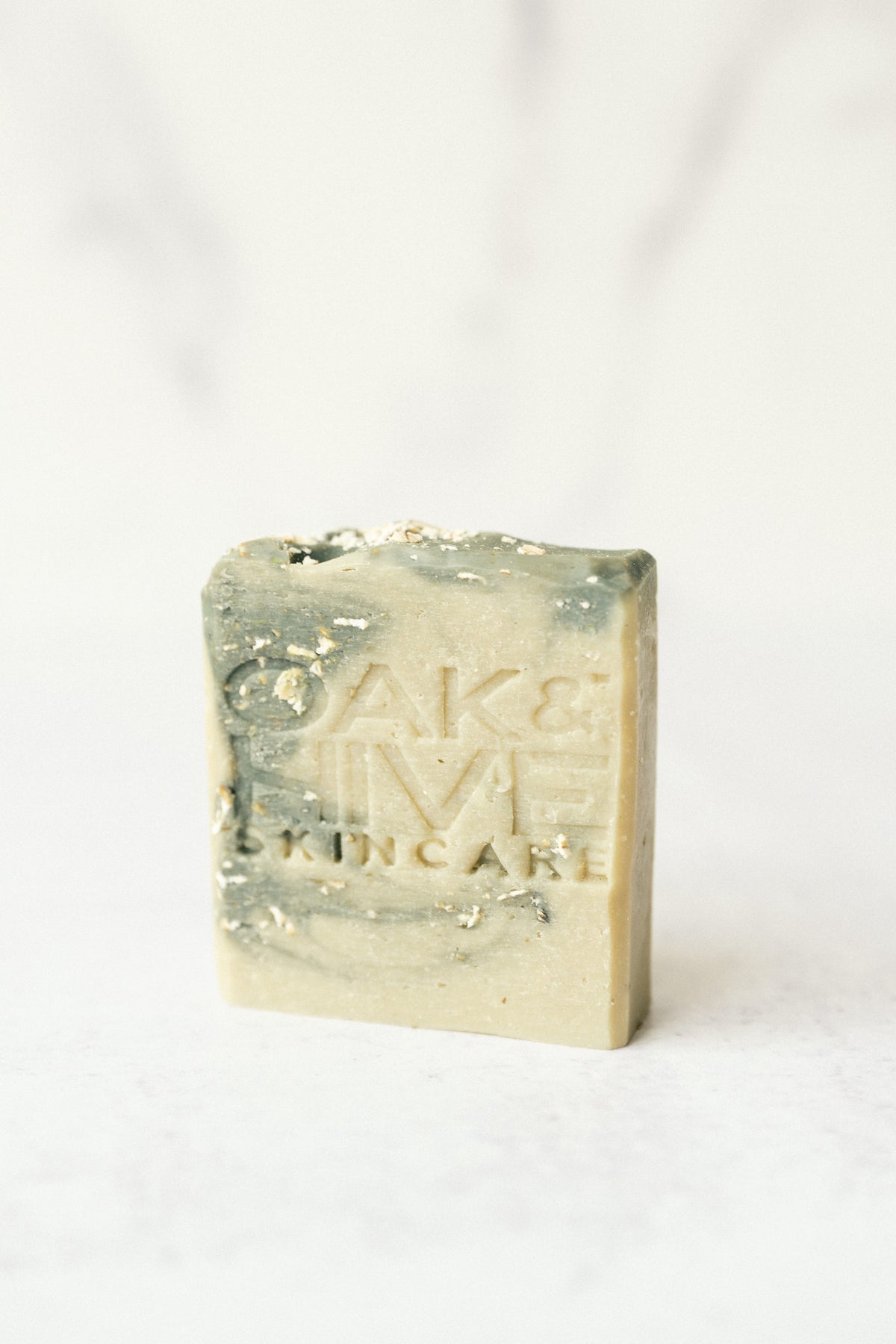 a tan and blue swirled bar of soap with white flakes in it on a white background
