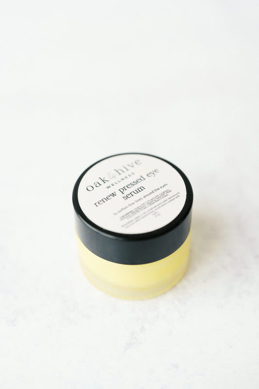 A jar of Oak & Hive Pressed Eye Serum with a white and black label, containing a yellowish serum.