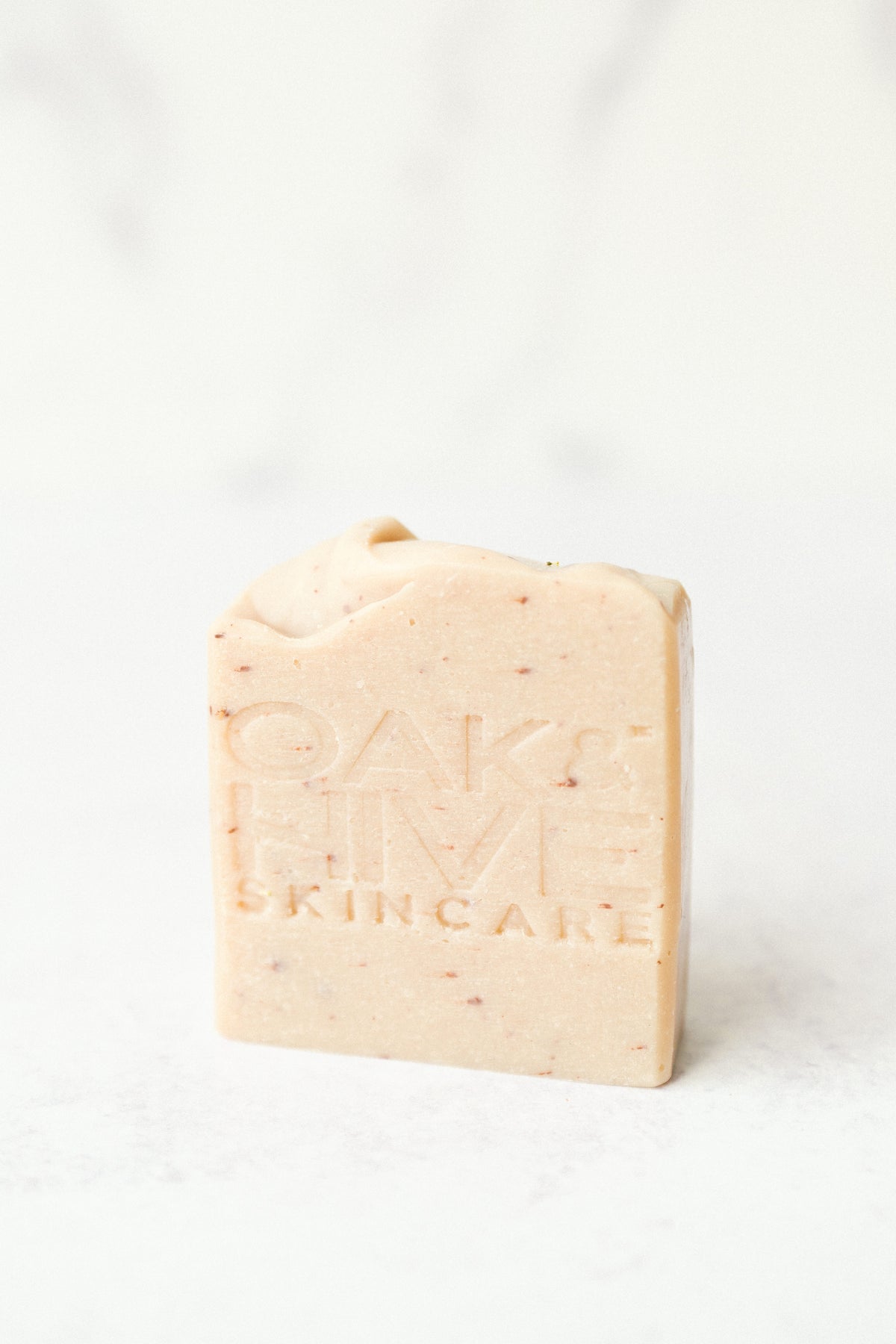 a pink bar of soap with dark pink spots inside with a white background.