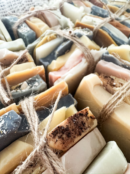 Assorted bars of soap tied together with twine on a white background