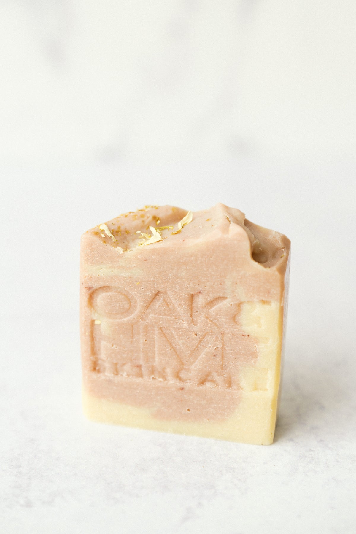 A pink and cream-colored swirled bar of soap with a white background.