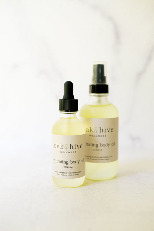 Two bottles of 'oak + hive' body oil on a white background