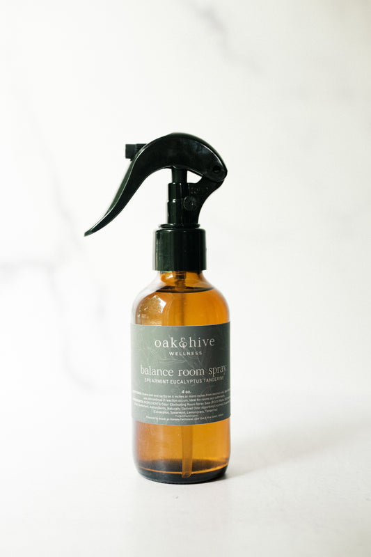 Amber glass spray bottle with black nozzle, with a green label on a white background